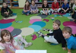 Dzieci wykonują ćwiczenia logopedyczne według obrazka nauczyciela