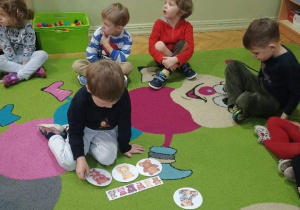 Dzieci grają w grę na kolorowym dywanie