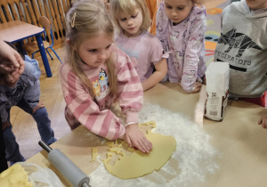 Dzieci wałkują ciasto na ciasteczka