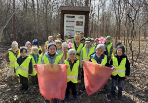 Dzieci z PM20 ubrane w kamizelki odblaskowe, rękawiczki i z workami na śmieci przygotowują się do sprzątania parku z okazji Galantego Sprzątania