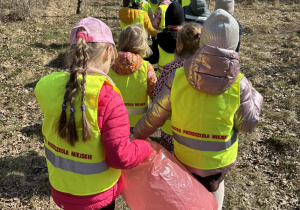 Dzieci idą parami z workami na śmieci, są gotowe do sprzątania świata.