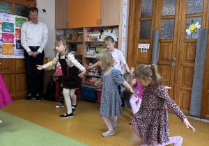 trzy dziewczynki wykonują ukłon baletowy