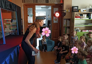 aktorka z Teatru rozmawia z dziećmi na widowni i pokazuje im pacynki