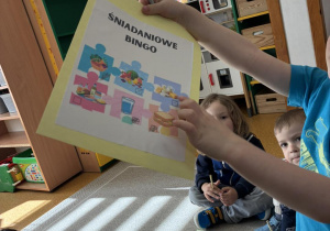 Zdjęcie przedstawia kartkę z napisem śniadaniowe bingo i ilustracjami pełnowartościowego jedzenia