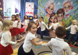 dzieci z najstarszej grupy skaczą po kole trzymając się za ręce