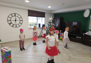 Dziewczynki w czerwonych spódniczkach i białych bluzkach stoją w szachownicy