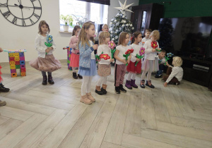 Dziewczynki stoją w grupie, trzymają kolorowe balony kwiatki