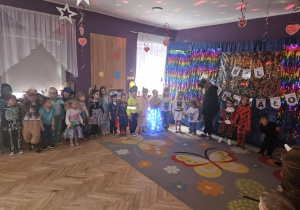 Dzieci stoją w okręgu i tańczą do karnawałowych utworów