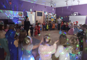 Dzieci stoją w okręgu i tańczą do karnawałowych utworów