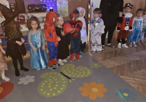 Dzieci stoją w linii i podają sobie czerwony balonik