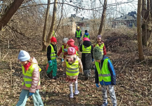 Dzieci w odblaskowych kamizelkach szukają śmieci w lasku na Rudzkiej Górze w Łodzi