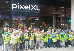 zdjęcie grupowe dzieci w kamizelkach odblaskowych przed wejściem do budynku Pixel XL
