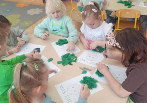 Dzieci wykonują pracę plastyczną z użyciem bibuły.