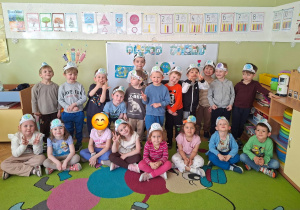 Zdjęcie grupowe grupy Średniaków na tle dekoracji z okazji Dnia Ziemi, na głowach mają opaski z ziemią