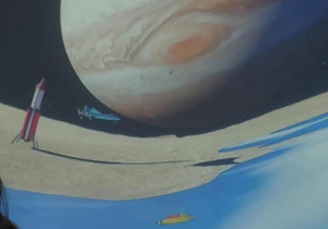 Dzieci leżą na poduszkach pod kopułą kina sferycznego i oglądają film edukacyjny o planetach.