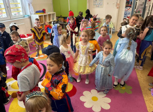 Dzieci tańczą podczas Balu Karnawałowego. Każde dziecko jest przebrane w kolorowe i wyjątkowe stroje.