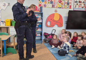 Dwie funkcjonariuszki policji rozmawiają z dziećmi na temat bezpieczeństwa.