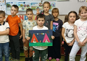 Zdjęcie grupowe dzieci z najstarszej grupy, prezentującej prace plastyczną na konkurs plastyczny Spartakiady