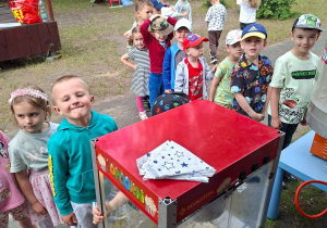 Dzieci czekają w kolejce przy maszynie do popkornu.