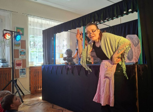Zdjęcie przedstawia aktorkę Teatru Pacuś słuchającą co odpowiadają dzieci.