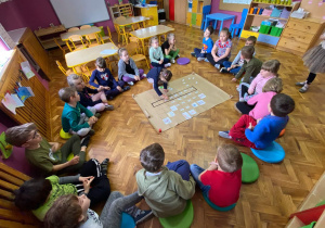 Dzieci rozwiązują krzyżówkę z hasłem EKOLOGIA.