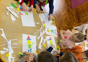 Praca plastyczna – dzieci układają pajacyka z figur geometrycznych.