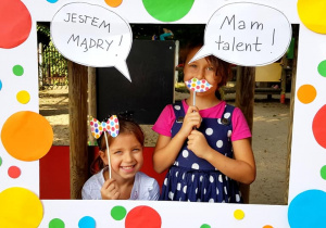 Dziewczynki pozują w ramce z napisami "Jestem mądry", "Mam talent"