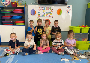 Dzieci pozują do zdjęcia na tle napisu "Dzień Przedszkolaka"