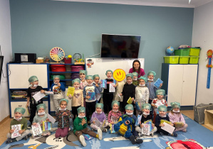 Na zdjęciu dzieci pozują do wspólnego zdjęcia wraz z prowadzącą warsztaty panią