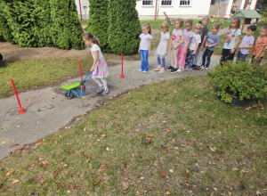 Dziecko bignie z taczką.