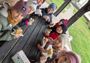 Dzieci przy stole spożywają posiłek