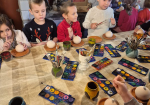 dzieci malują dzieła wytworzone z gliny