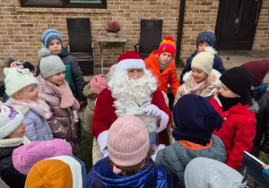 dzieci stoją wokół Mikołaja