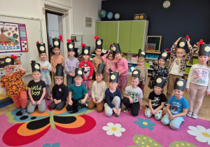 dzieci pozują do zdjęcia grupowego w czapkach górniczych