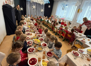 dzieci oczekują na rozpoczęcie świątecznego obiadu przy zastawionych stołach