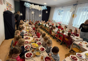 dzieci oczekują na rozpoczęcie świątecznego obiadu przy zastawionych stołach