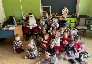 dzieci pozują do zdjęcia grupowego z mikołajem