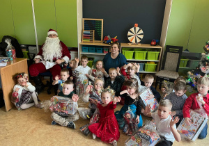 dzieci pozują do zdjęcia grupowego z mikołajem