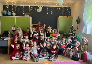 dzieci pozują do zdjęcia grupowego z mikołajem
