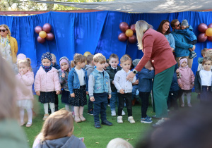 Pasowanie na przedszkolaka. Dzieci z najmłodszych grup śpiewają piosenkę na scenie.